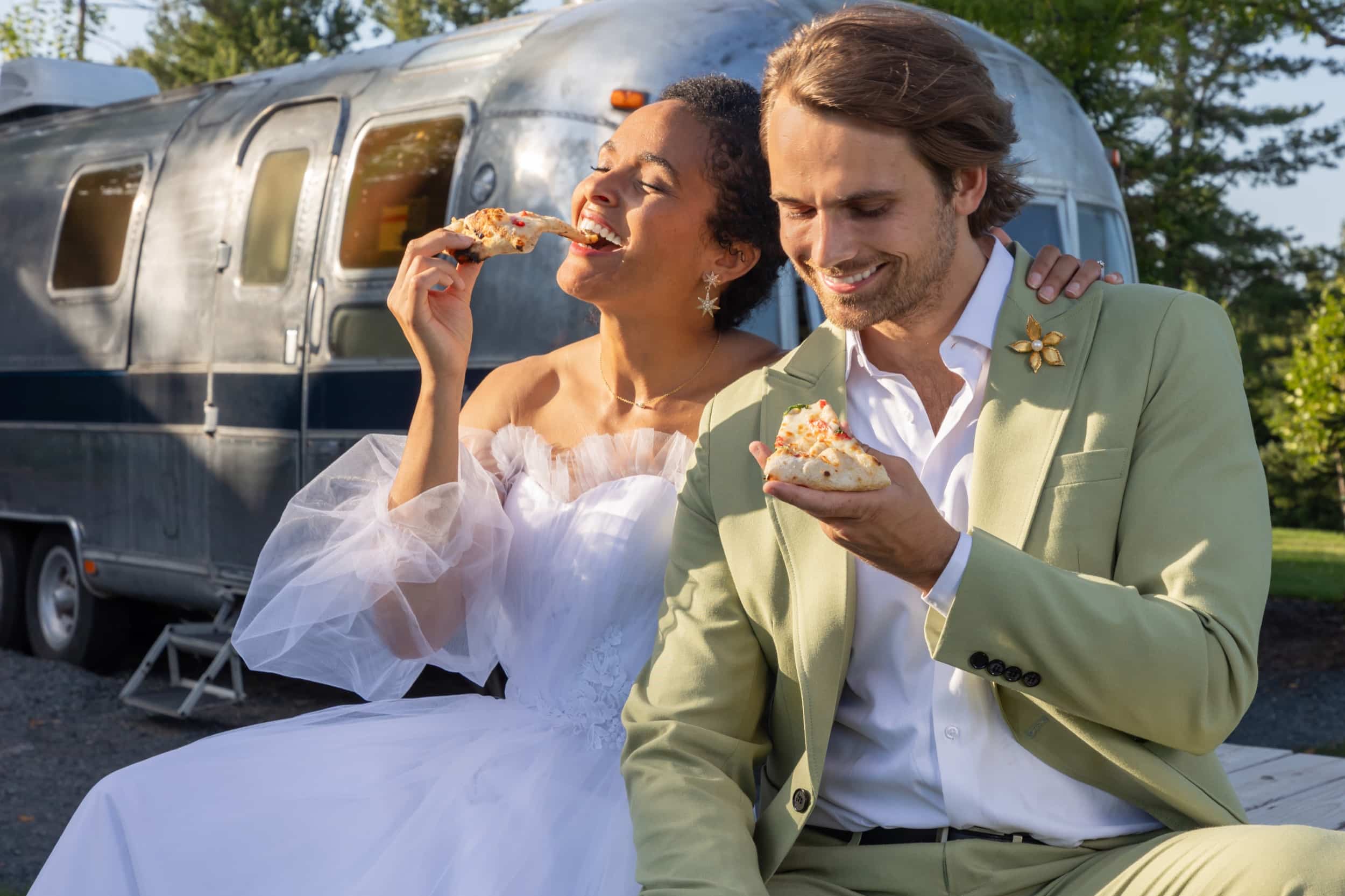 A couple eating pizzas together