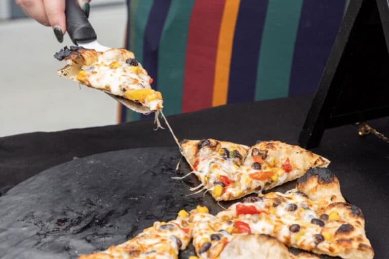 A close-up of a pizza slice getting picked up