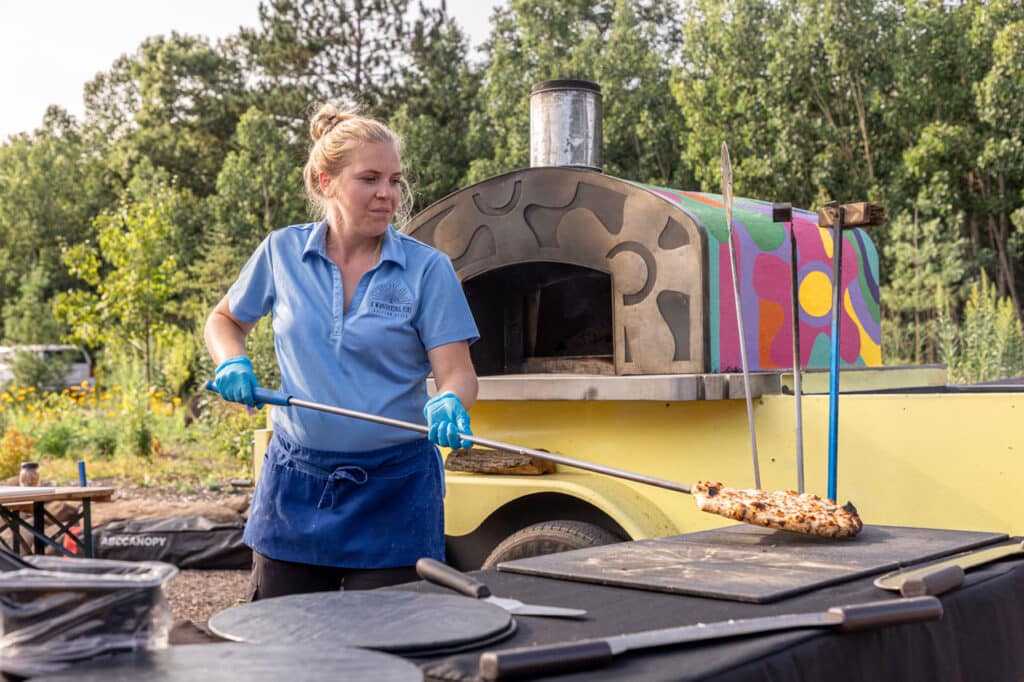 A Wandering Fire staff serving pizza
